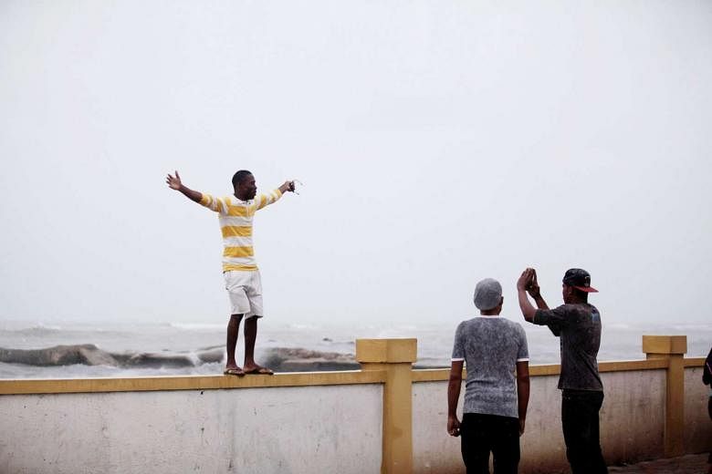 A man posing for a picture beside the sea before Hurricane Matthew battered Haiti. More than 6,400 people have been evacuated to temporary shelters. Forecasts say landslides are likely before the storm moves on to Cuba. 