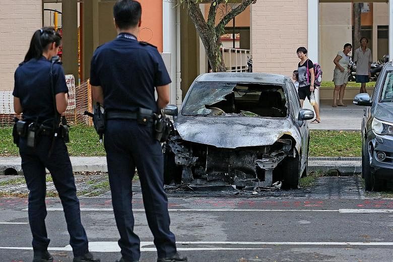 The car in the Ang Mo Kio carpark is reduced to a blackened heap. A fire broke out in its engine compartment on Tuesday afternoon. Residents nearby said they heard loud bangs as the car burned.