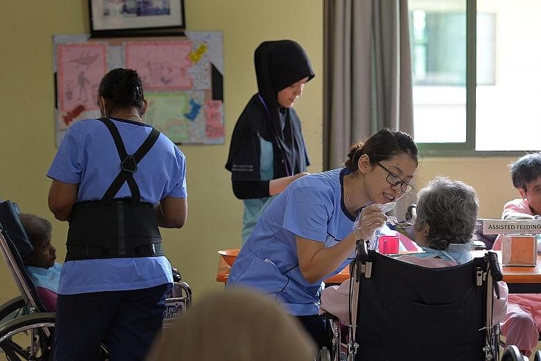 Nursing aide Nyein Pyae Sone (right), 34, feeding a resident at Jamiyah Nursing Home. Some 85 per cent of the home's care staff are foreigners, mainly from the Philippines, Myanmar and India.