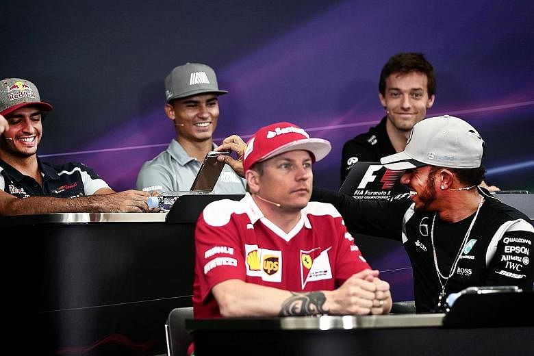 Left: Mercedes driver Lewis Hamilton (front, right) shows his phone to Toro Rosso's Carlos Sainz Jr at a press conference with Ferrari's Kimi Raikkonen (front, left), Manor's Pascal Wehrlein (centre) and Renault's Jolyon Palmer. Above: Lewis Hamilton