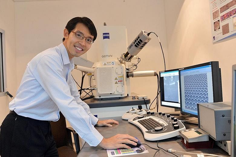 Dr Wong Liang Jie with a scanning electron microscope which the researchers use to check graphene for defects and to make sure it really is a single layer of atoms.