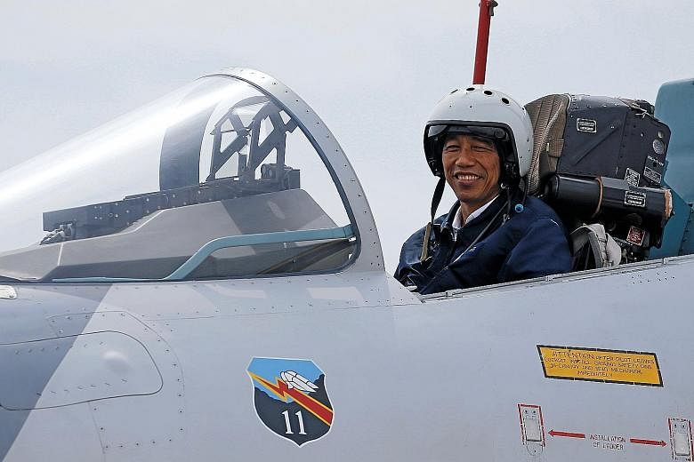 Indonesian President Joko (above) in the cockpit of a Sukhoi fighter jet while attending a military exercise at the Ranai military airbase on Natuna Island yesterday. He was in the Natunas to officiate at the opening of a new airport terminal as well