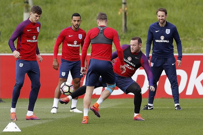 England players (from left) Theo Walcott, Jamie Vardy (back facing) and Wayne Rooney during a training session as caretaker coach Gareth Southgate looks on.
