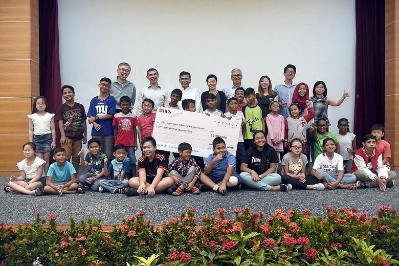 Beneficiaries of The Straits Times School Pocket Money Fund with a cheque for a $500,000 donation to the fund at an Appreciation Day event yesterday. With them are (from back row, left) fund trustee Sia Cheong Yew; fund chairman and ST editor Warren 