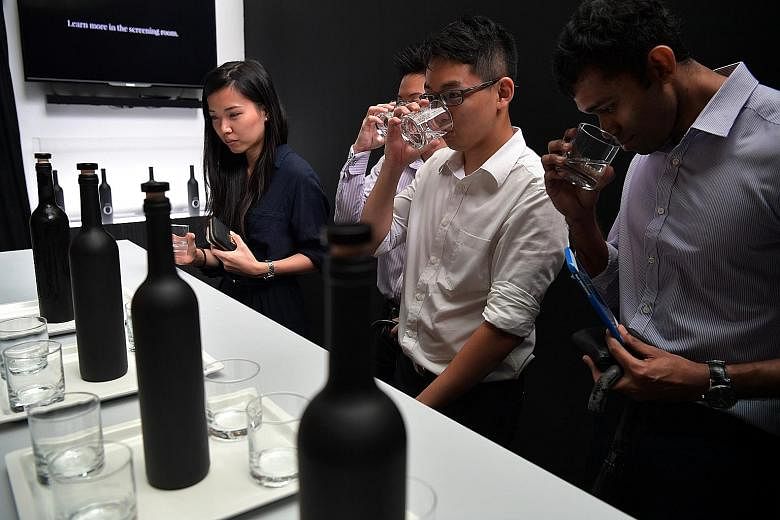 Visitors sampling "Asia's most expensive water", priced at $1,260 a bottle, at a pop-up bar in Ocean Financial Centre. The campaign was launched by non-profit group Lien Aid yesterday to raise awareness that clean water is a luxury for many poor peop