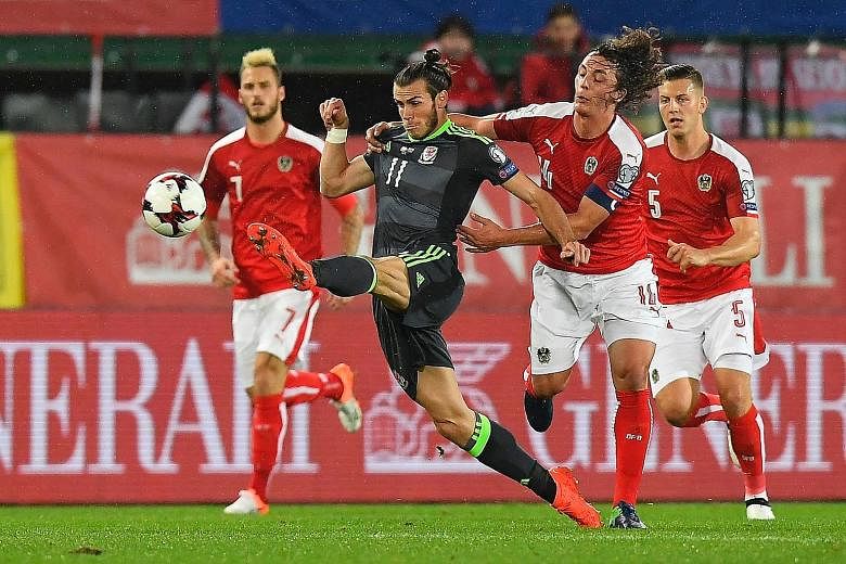 Wales forward Gareth Bale (centre) keeps possession as Austria's Julian Baumgartlinger lurks. Marko Arnautovic (No. 7) and Kevin Wimmer (No. 5) both made crucial touches during the World Cup qualifier. Arnautovic netted a brace while Wimmer scored an