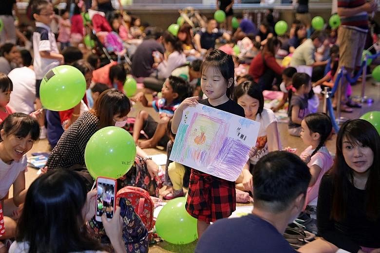 Five-year-old Lim Yu Han poses with her artwork for her mother, 38-year-old Maggie Chen. The girl was among more than 1,600 children who spent Children's Day yesterday letting their creativity run wild at the Esplanade. While those between five and 1