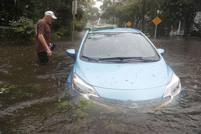 A car sitting in a flooded street in St Augustine, Florida, as Hurricane Matthew passed through the area on Friday. As of 8am yesterday, the National Hurricane Centre had downgraded Matthew to a Category 1 hurricane with maximum sustained winds of 13