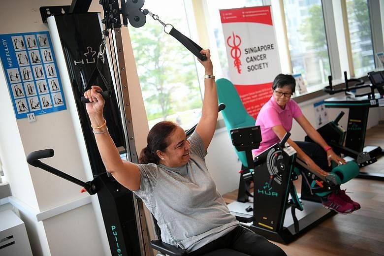 Lymphoma survivor Rajwant Kaur (far left) exercising at the gym at the Singapore Cancer Society's rehabilitation centre in Jurong East, which was officially launched yesterday. She credits her stronger body to the programme that the centre customised