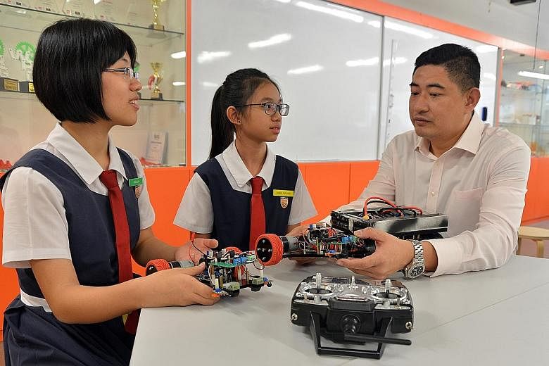 Woo Jie Lyn (far left) and Angel Yip with teacher Indra Ahmad. The two girls are members of the Paya Lebar Methodist Girls' School (Secondary) robotics group.