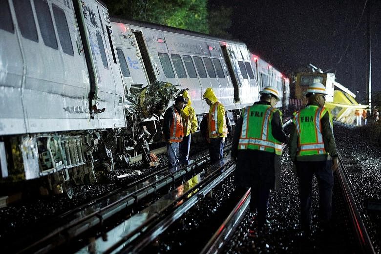 Emergency responders working at the scene of the derailed train near the community of New Hyde Park on Long Island in New York.