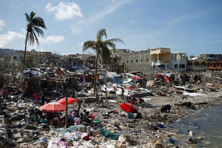 Homeless people gather in makeshift shelters on the shore in Jeremie, Haiti, in the aftermath of Hurricane Matthew. At least 13 people on the Caribbean island have died from cholera since the storm hit. The disease causes severe diarrhoea and can kil