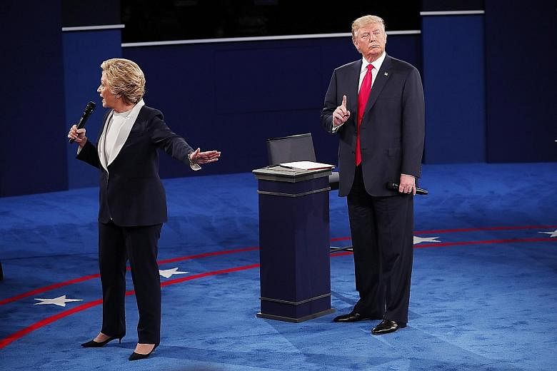 Mrs Clinton and Mr Trump during their second presidential debate, held at Washington University in St Louis, Missouri, on Sunday. Pundits felt that Mr Trump did better than expected, while his rival played it safe throughout the 90-minute debate. Sti