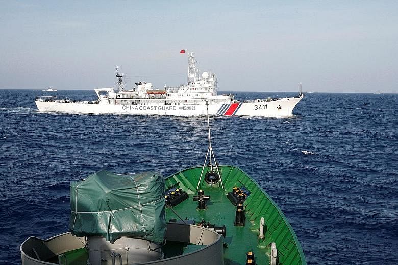 A China Coast Guard ship (top) is seen near a Vietnam marine guard ship in the South China Sea in 2014. A new security framework can help avoid tense scenes like this, China believes.