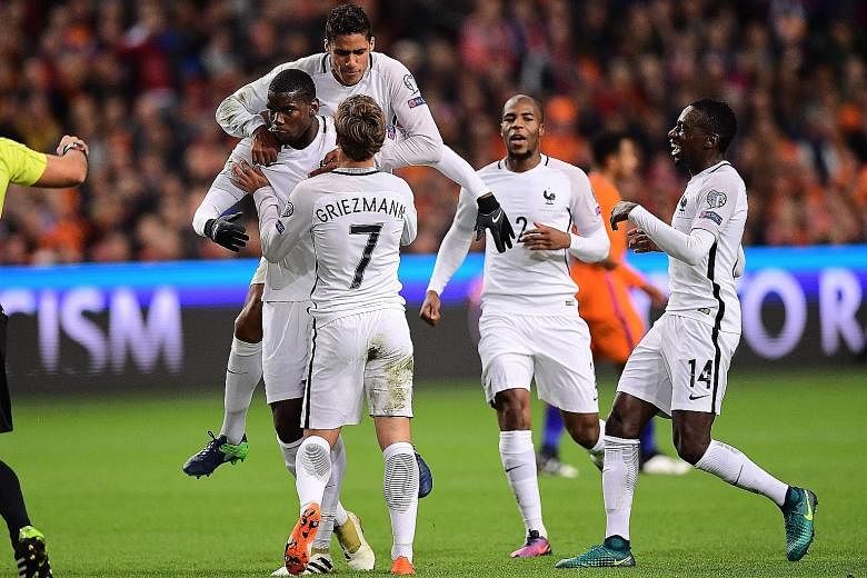 France midfielder Paul Pogba (left) is congratulated by team-mates after scoring from 25 metres out against the Netherlands.