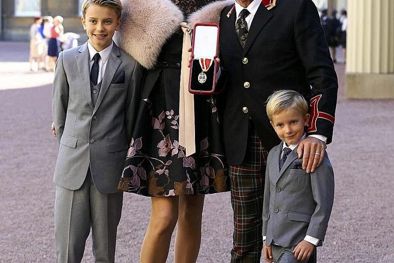 British singer Rod Stewart, 71, at Buckingham Palace with his third wife Penny Lancaster, 44, and two children, Alastair, 10, and Aiden, five, after receiving his knighthood. Prince William knighted him on Tuesday for his services to music and charit