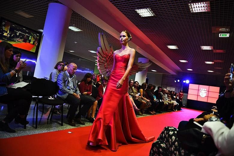 A model wears a creation by designer Micaela Oliveira during a fashion show by Benfica at the Stadium of Light in Lisbon.