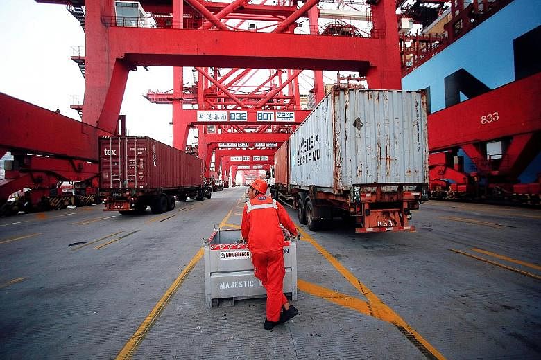 Shipping volumes at Shanghai's Yangshan port (right) and other trading hubs in China could slow further as demand for Chinese goods overseas continues to weaken. Exports for last month shrank by 10 per cent - far more than the 3 per cent expected - e