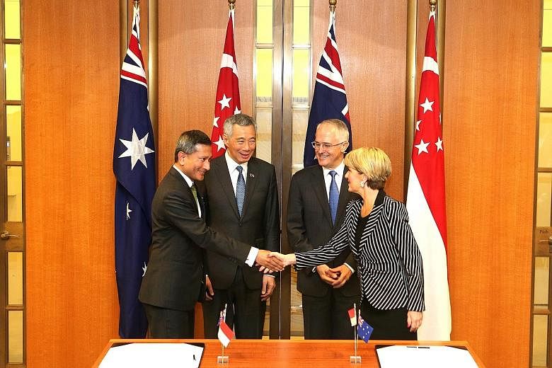Singapore Foreign Minister Vivian Balakrishnan and his Australian counterpart Julie Bishop acknowledging the signing of a memorandum of understanding on science and innovation, one of the four CSP agreements, in Canberra's Parliament House yesterday,