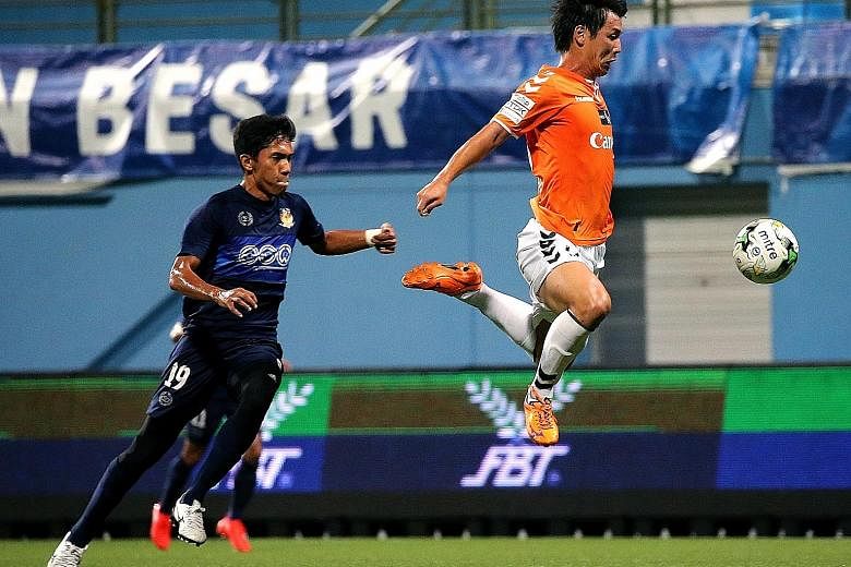 Atsushi Kawata lunging for the ball, as Hougang defender Nurhilmi Jasni races to keep up with him. Kawata opened the account for Albirex in the fourth minute with his 13th goal of the season.