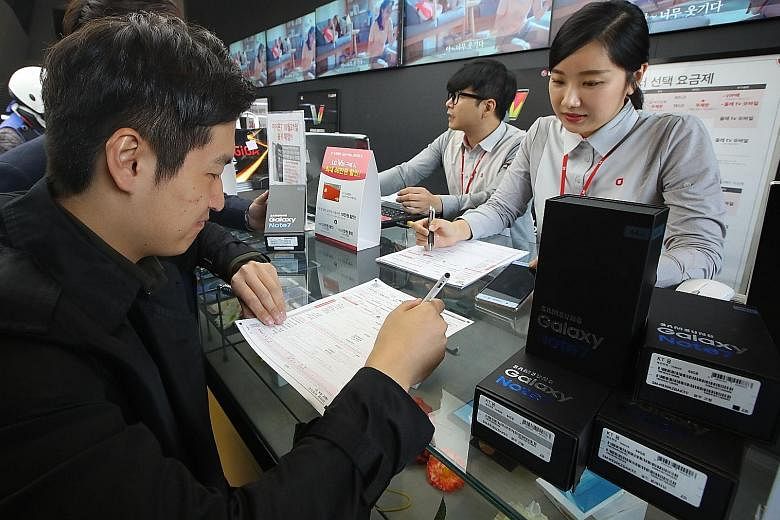 Customers returning their Samsung Note7 mobile phones at a dealership in Seoul yesterday. Samsung shares have slumped more than 8 per cent this week, wiping about US$20 billion (S$28 billion) from their market value.