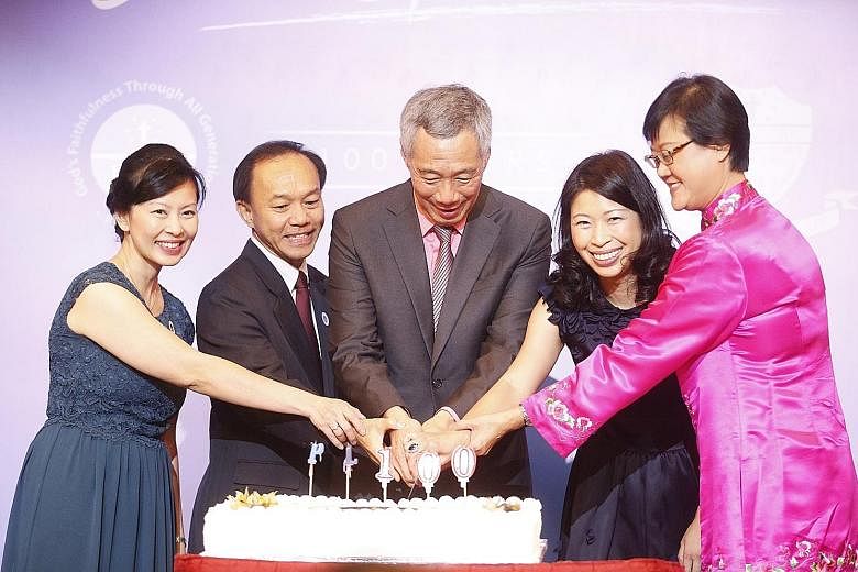 PM Lee cutting a cake last night at the Orchard Hotel ballroom with (from left) Mrs Quek Li Gek, principal of PLMGS (Secondary); Professor Hum Sin Hoon, chairman of the Board of Management; Mrs Quahe-Lim Su-Lynn, president of the alumni; and Ms Chua 