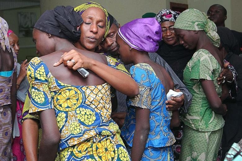 Mrs Oludolapo Osinbajo (second from left), wife of Nigerian Vice-President Yemi Osinbajo , consoling one of the 21 released schoolgirls in Abuja on Thursday. The girls were freed after the Red Cross and the Swiss government brokered a deal with Boko 