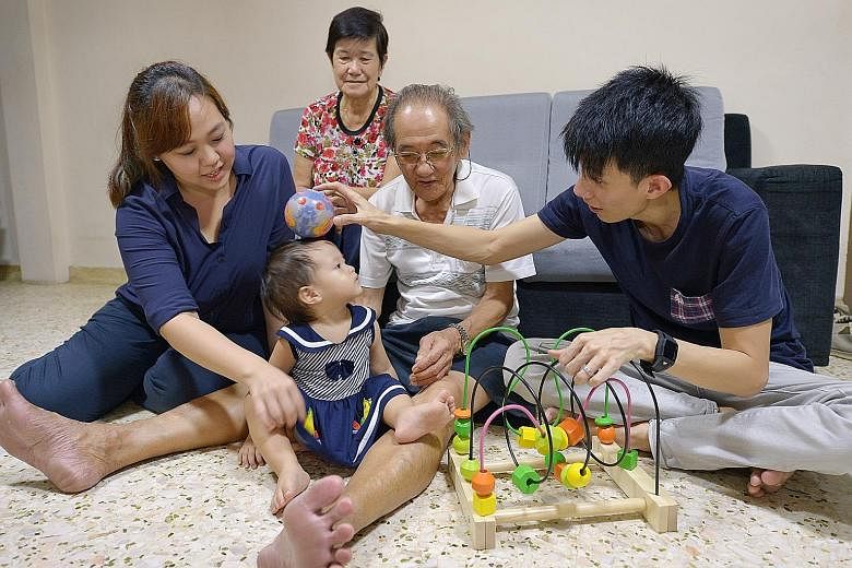 Mrs Stephanie Tan, her husband Sean, and his parents Tan Kim Hok, 76, and Madam Oh Pang Huck, 71, having a good time with 15-month-old Sarah in her grandparents' flat in Ang Mo Kio. The young couple have been shuttling between their parents' places w