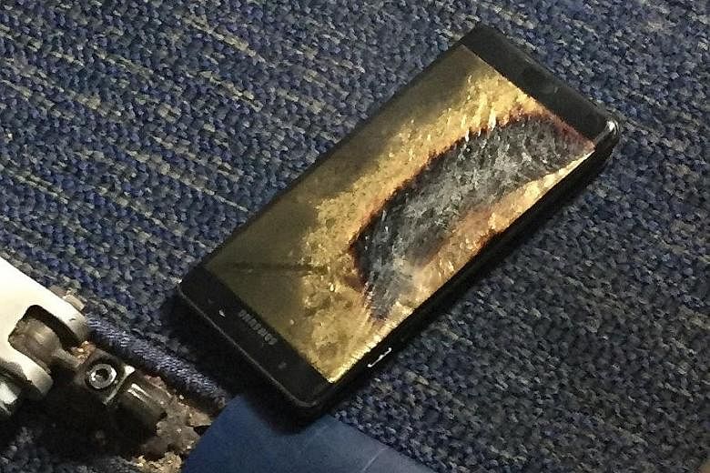 A Southwest Airlines passenger's Note7 replacement phone caught fire inside a plane in the US earlier this month. Workers taking down a billboard for Samsung Electronics' Galaxy Note7 from a building in Seoul on Friday. The company has yet to identif