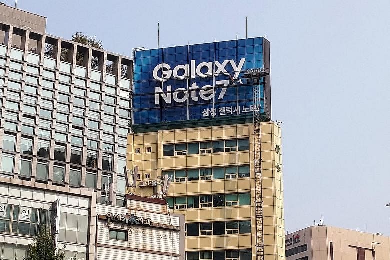 A Southwest Airlines passenger's Note7 replacement phone caught fire inside a plane in the US earlier this month. Workers taking down a billboard for Samsung Electronics' Galaxy Note7 from a building in Seoul on Friday. The company has yet to identif