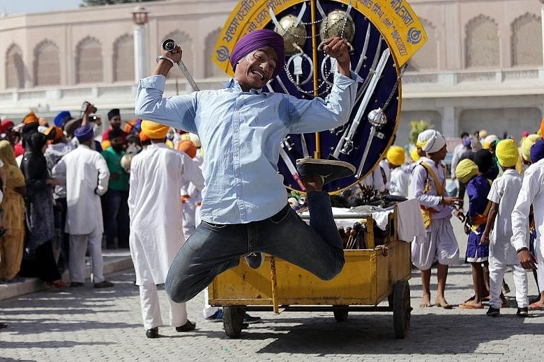 A young Sikh displaying his skill with a sword while demonstrating gatka, an ancient Sikh martial art, during a religious procession in Amritsar, India, yesterday. It was the eve of the 482nd birth anniversary of the fourth Guru or master of the Sikh