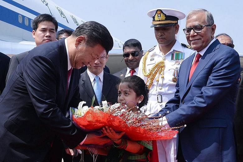 Mr Xi being greeted by Bangladeshi President Abdul Hamid upon his arrival in Dhaka.