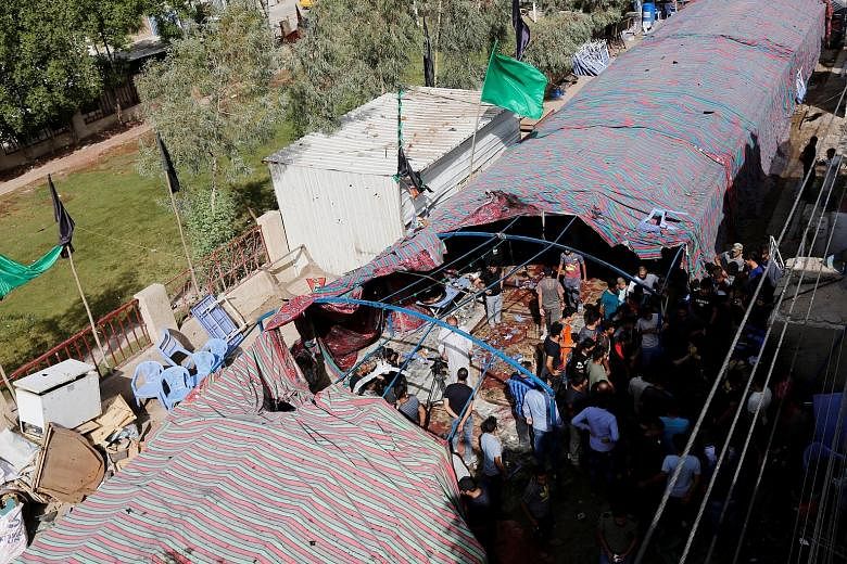 The site of the suicide bomb attack in the al-Shaab district of Baghdad yesterday. The bomber detonated an explosive vest inside a tent filled with people taking part in Shi'ite Ashura rituals, killing at least 41 people and wounding 33.