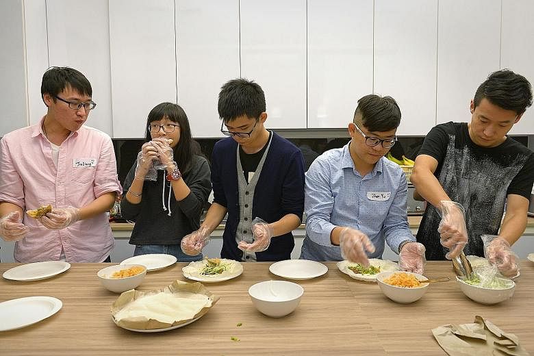 Students from China (from far left) Xiang Jialiang, 25; Li Ruotong, 17; Tan Wenhao, 18; Wang Zhenyu, 23; and Liu Xingda, 25, learning to make popiah at a mystery supper session. 