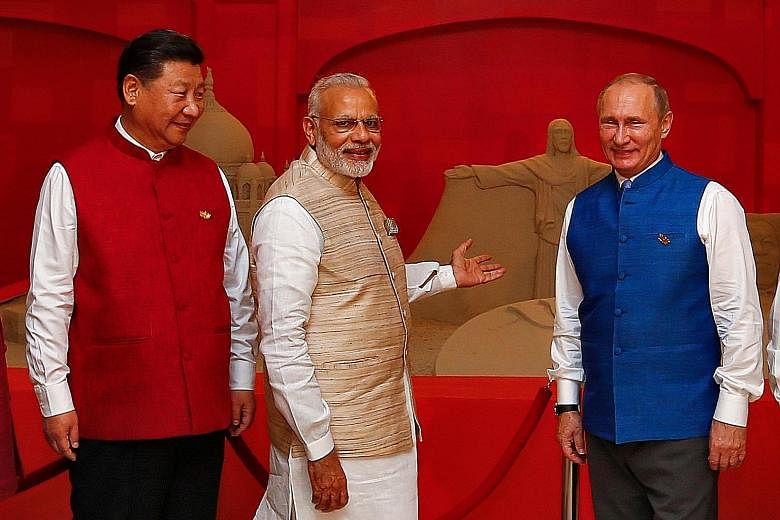 (From left) Mr Xi and Mr Modi with Russian President Vladimir Putin at the eighth annual Brics summit on Saturday. Brics leaders issued a joint declaration on a range of measures, including the setting up of a new credit ratings agency.
