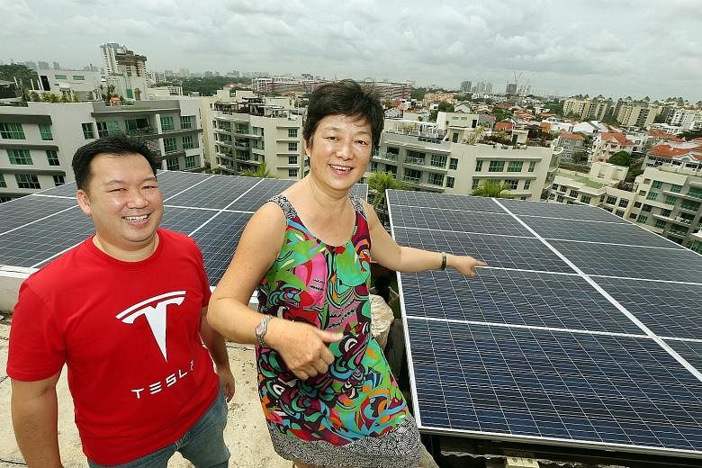 Mrs Pho Hong Ling, 61, and her son Robin on the rooftop of her penthouse condominium in Bukit Timah where 20 solar panels have been installed, generating about 20 kilowatt hours of energy a day. Mr Pho estimates this will help cut about half of the m