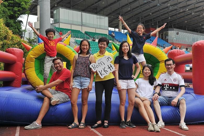Ms Wee (in yellow) and three generations of her KKH-born family (from far left): Primary 2 pupil Callum Tam, seven; Mr Joel Tam, 41, a creative director; JC 1 student Nicole Tan, 17; Secondary 3 student Natalie Tan, 15; Primary 4 pupil Nadine Tan, 10