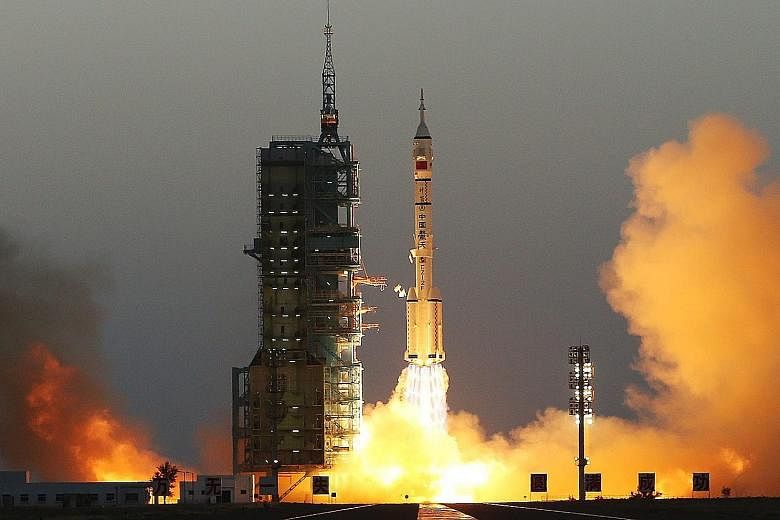 Far left: The Long March-2F rocket, carrying the Shenzhou-11 spacecraft, taking off from Jiuquan, Gansu province, yesterday. Left: Astronauts Jing (at right) and Chen in the Shenzhou-11 spacecraft.
