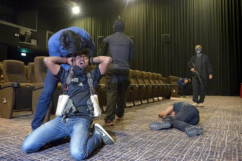 A "terrorist" strapping an explosive vest on a hostage in a cinema, as part of a media preview to an islandwide counter-terrorism exercise that started yesterday and is set to end early this morning. The exercise comes as Singapore ramps up its readi