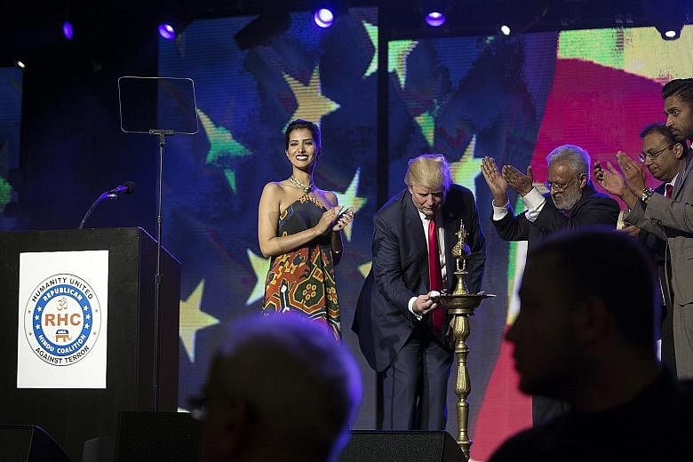 Mr Trump lighting an oil lamp before addressing the rally organised by the Republican Hindu Coalition in New Jersey at the weekend. Beside him is Mr Shalabh Kumar, the coalition's founder and one of his biggest fund-raisers. In a warm speech towards 
