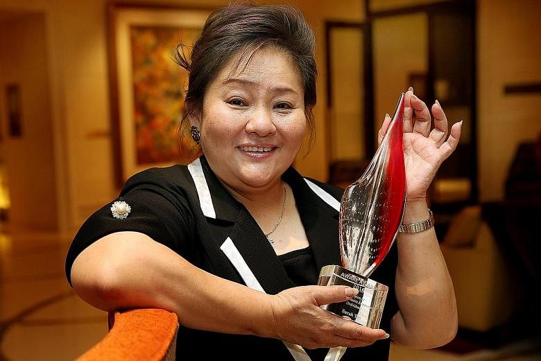 Madam Sarah Tan with her award from Aware. The bun shop owner has housed more than 50 people over a decade and hired more than 10 of them at her stalls.