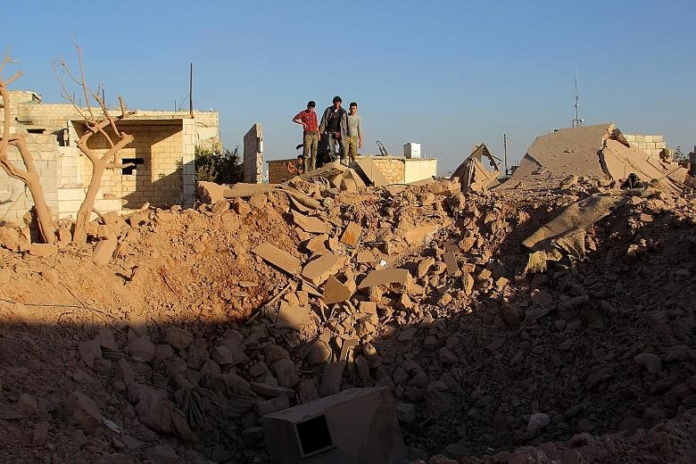 People inspecting an air strike's aftermath in the Syrian rebel-held village of Owaijel on Monday. In addition to military operations in the Middle East, the US must direct foreign policy in the middle of a markedly bitter election.
