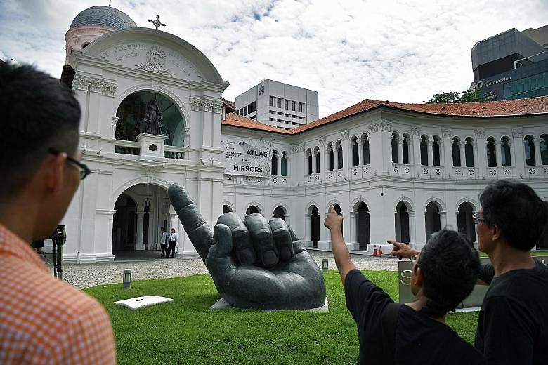 A large hand emerges from the ground, index finger pointing skyward. What lies in the earth beneath? Singaporean artist Lim Soo Ngee (far right) hopes viewers will let their imagination run wild and ponder this question. In his own imagination, this 