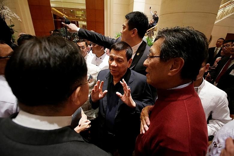 Mr Duterte (centre) chatting with members of the Filipino community at the Grand Hyatt Beijing hotel in China yesterday. He said that he would be asking for "the help of China" during his four-day state visit.