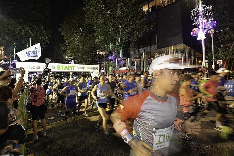 Participants in last year's Standard Chartered Marathon Singapore beginning their races at the starting point along Orchard Road.