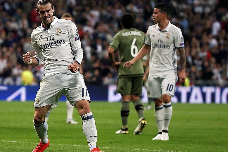 Left: Real Madrid's Gareth Bale celebrating his first European goal in almost two years. His side completed a 5-1 victory in the Champions League group-stage match against Legia Warsaw on Tuesday. Below: Spanish police facing off against supporters o