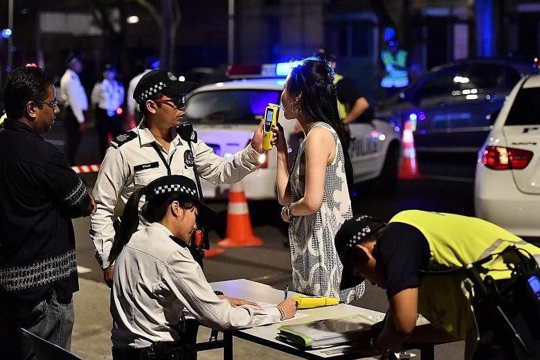 A drink-driving suspect inside a police van. Fifteen men and three women aged between 22 and 58 were arrested in the operation early yesterday morning. A motorist suspected of drink-driving being tested using a hand-held breath analyser. Police held 
