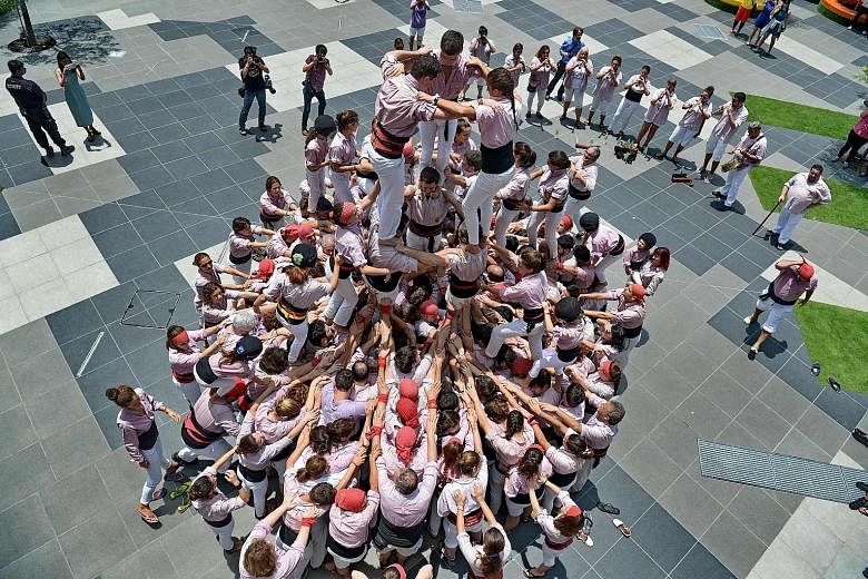 Castellers from Spain forming a human tower, or castell, in Sentosa yesterday. The 290 castellers from the Minyons de Terrassa, here as part of Catalan Week, climbed deftly on each other's shoulders, reaching a height of 12.5m. The Catalan tradition,