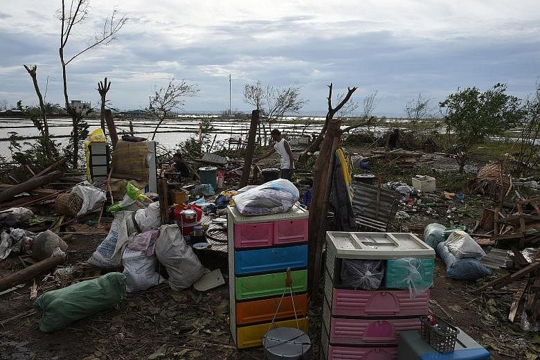 A resident surveying the remains of his house in Cabagan town in Isabela province yesterday after it was destroyed by Super Typhoon Haima. The storm made landfall in Isabela late on Wednesday night.
