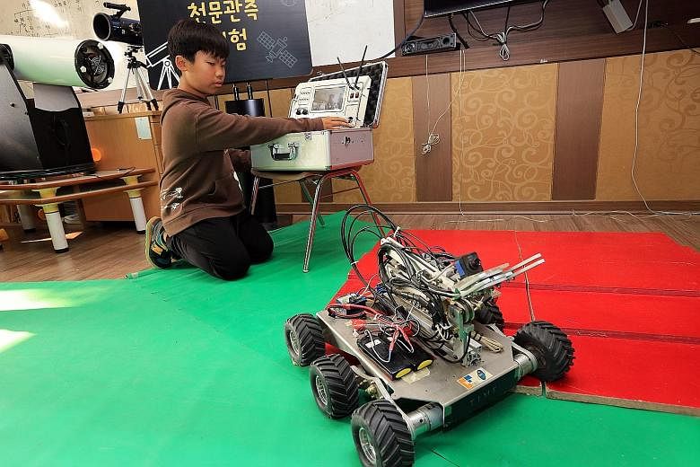 A pupil from Meewon Elementary School's Jangrak branch learning how to control a robot on display in the school's "special room".